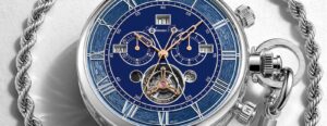 A contemporary pocket watch displayed open on a desk with its mechanical movement visible