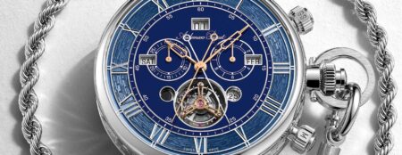 A contemporary pocket watch displayed open on a desk with its mechanical movement visible