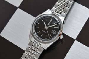 Where Value Meets Virtue in Six Affordable Mechanical Watches Six affordable mechanical watches arranged on a clean editorial tabletop