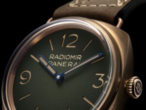 Panerai Radiomir Bronzo PAM00760 with green dégradé dial and bronze case beside a classic wooden yacht
