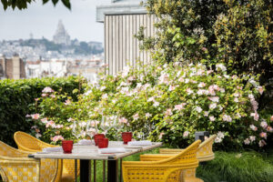 Le Jardin de Cheval Blanc Paris Reopens Above the Seine on May 22, 2026 Le Jardin de Cheval Blanc Paris seventh-floor summer terrace with red and white seating and lush flowers
