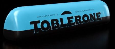 Toblerone’s Ferrari Luce Jab Takes the EV Design Debate Beyond Cars Ferrari Luce electric supercar beside a Toblerone-inspired angular chocolate package concept