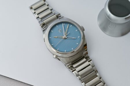 A group of modern luxury chronograph watches arranged on a dark studio surface
