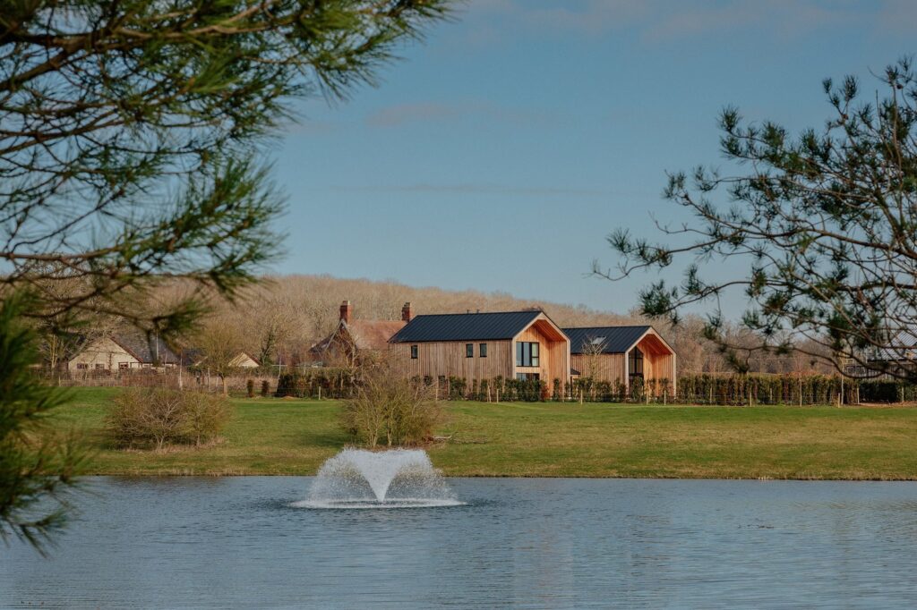 Nobu Woolfox Will Bring a 185-Acre Countryside Retreat to Rutland Rendering-style view of a luxury countryside hotel retreat set beside a lake in Rutland