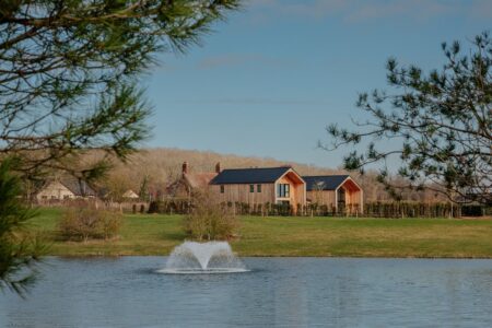 Rendering-style view of a luxury countryside hotel retreat set beside a lake in Rutland
