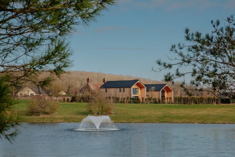 Rendering-style view of a luxury countryside hotel retreat set beside a lake in Rutland