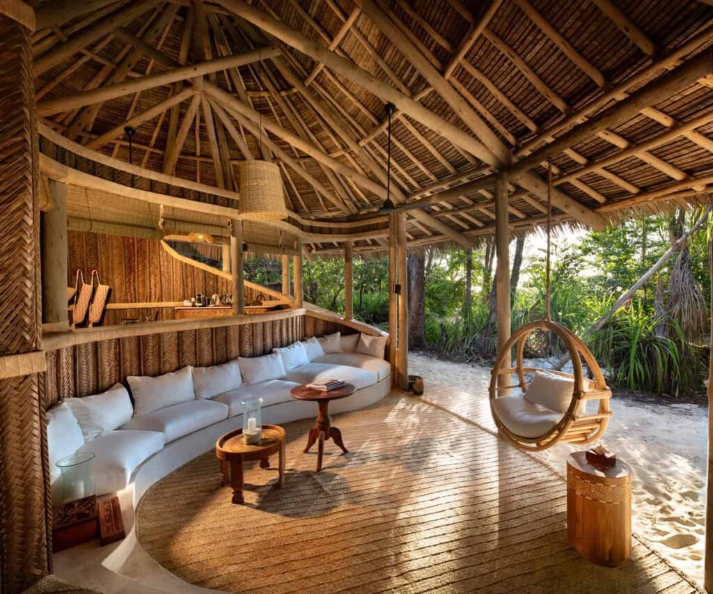 &BEYOND Mnemba Island Is Zanzibar’s Barefoot Private-Island Escape Open-air beach banda at &BEYOND Mnemba Island in Zanzibar with white sand and turquoise water