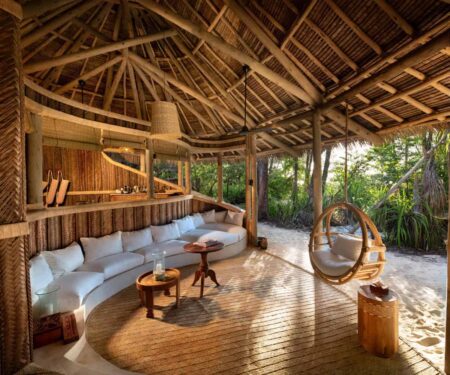 &BEYOND Mnemba Island Is Zanzibar’s Barefoot Private-Island Escape Open-air beach banda at &BEYOND Mnemba Island in Zanzibar with white sand and turquoise water