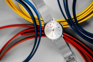 Mondaine Doppio Bauhaus Inspired watch with geometric colour-theory dial on Milanese bracelet
