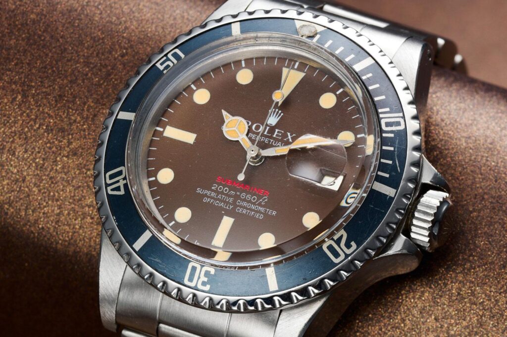 Vintage dive watch with faded bezel and warm aged lume showing natural patina