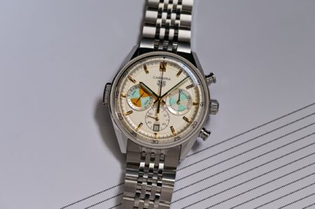 Selection of summer-ready wristwatches on a beach towel near sunglasses and sea water