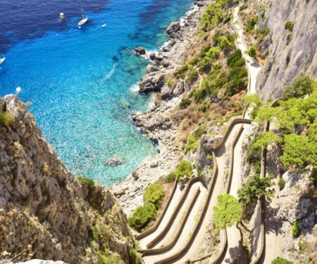 Seven Amalfi Coast Moments That Only Make Sense by Yacht Luxury yacht anchored off Capri on the Amalfi Coast at sunset