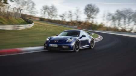 Porsche 911 on a winding road at dusk