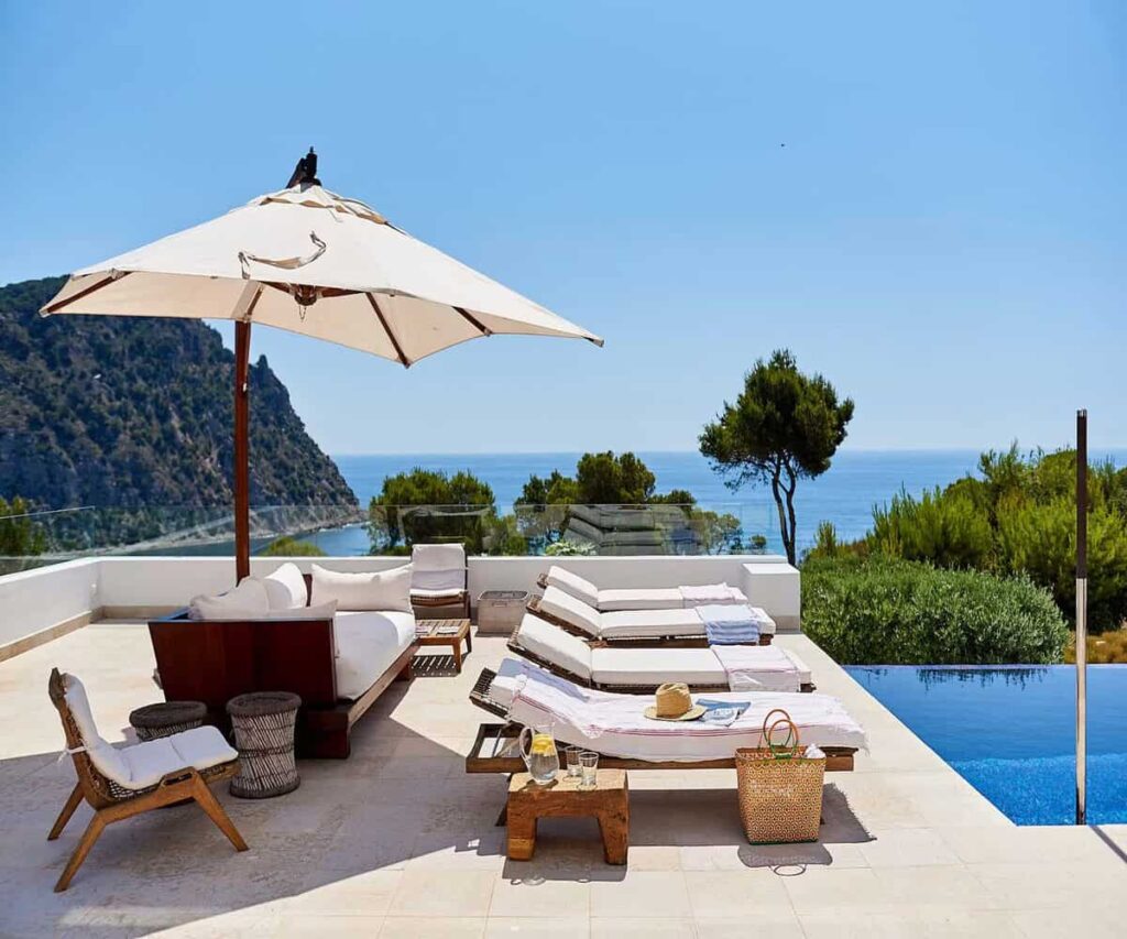 Where to Stay in Ibiza for the Beach That Actually Fits Your Trip Ibiza coastline with turquoise water and villas near the beach