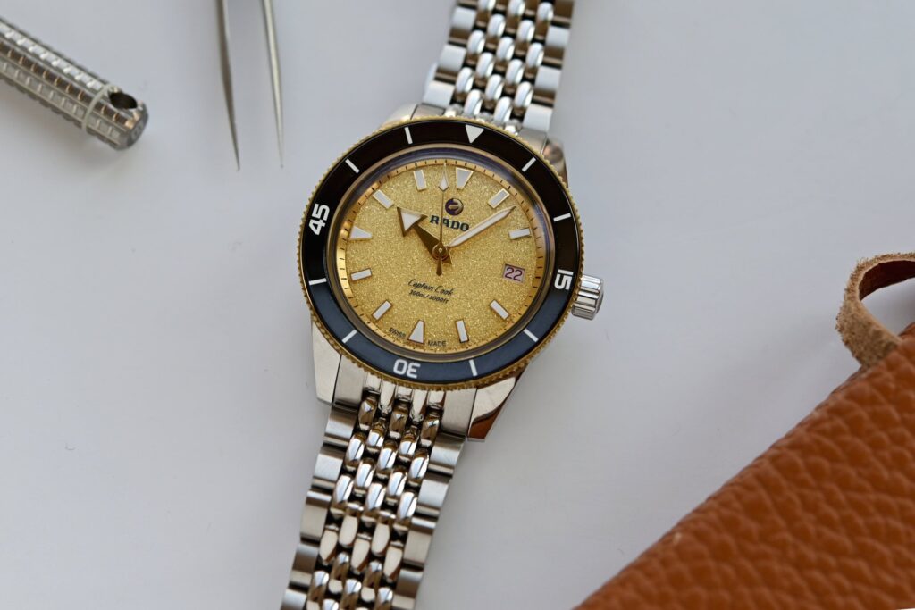 Rado Captain Cook 39mm watch with sparkling gold dial and black ceramic bezel