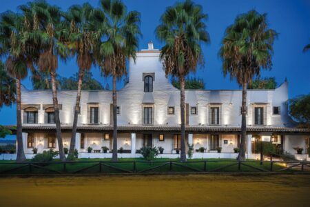 Restored Spanish heritage hotel courtyard with ceramic tiles and warm evening light