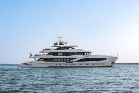 Luxury yacht cruising near a modern Qatar waterfront marina at sunset