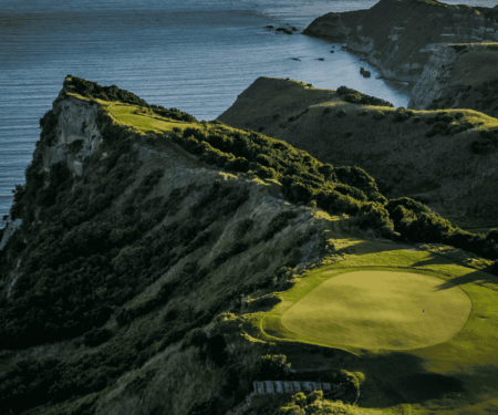 What a New Zealand Golf Trip Really Demands From You Golfer looking across a dramatic coastal fairway in New Zealand