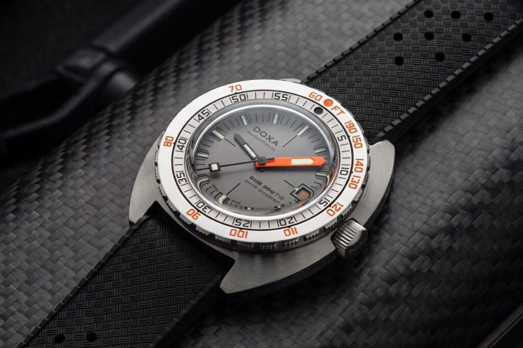 Doxa’s SUB 300 Ti5 Clive Cussler Brings Titanium to the Classic Diver Doxa SUB 300 Ti5 Clive Cussler Edition titanium dive watch with grey layered dial and black rubber strap