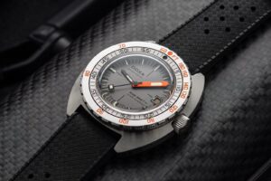 Doxa’s SUB 300 Ti5 Clive Cussler Brings Titanium to the Classic Diver Doxa SUB 300 Ti5 Clive Cussler Edition titanium dive watch with grey layered dial and black rubber strap