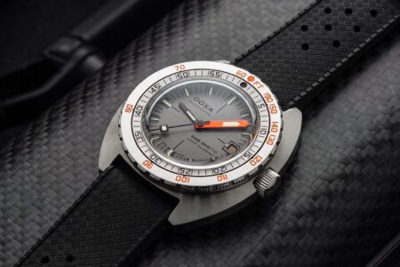Doxa’s SUB 300 Ti5 Clive Cussler Brings Titanium to the Classic Diver Doxa SUB 300 Ti5 Clive Cussler Edition titanium dive watch with grey layered dial and black rubber strap