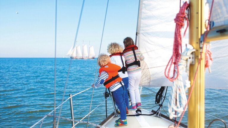Child studying with a private tutor aboard a luxury yacht at sea