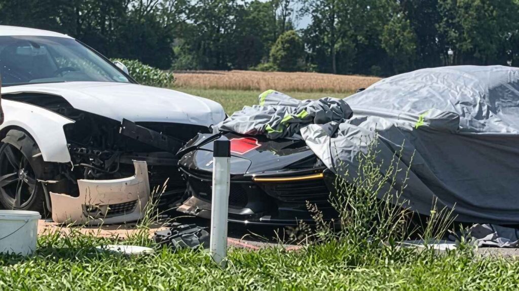 Ferrari Daytona SP3 Damaged in Storm-Hit Cavalcade Crash Ferrari Daytona SP3 with exposed carbon fibre parked roadside under a protective cover after a wet-weather crash