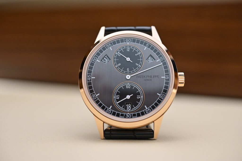 A mechanical wristwatch dial with off-centre regulator-style hands and sub-dials