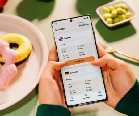 10 eSIM Providers That Make Luxury Travel Easier Traveller using an eSIM app on a smartphone in an airport lounge