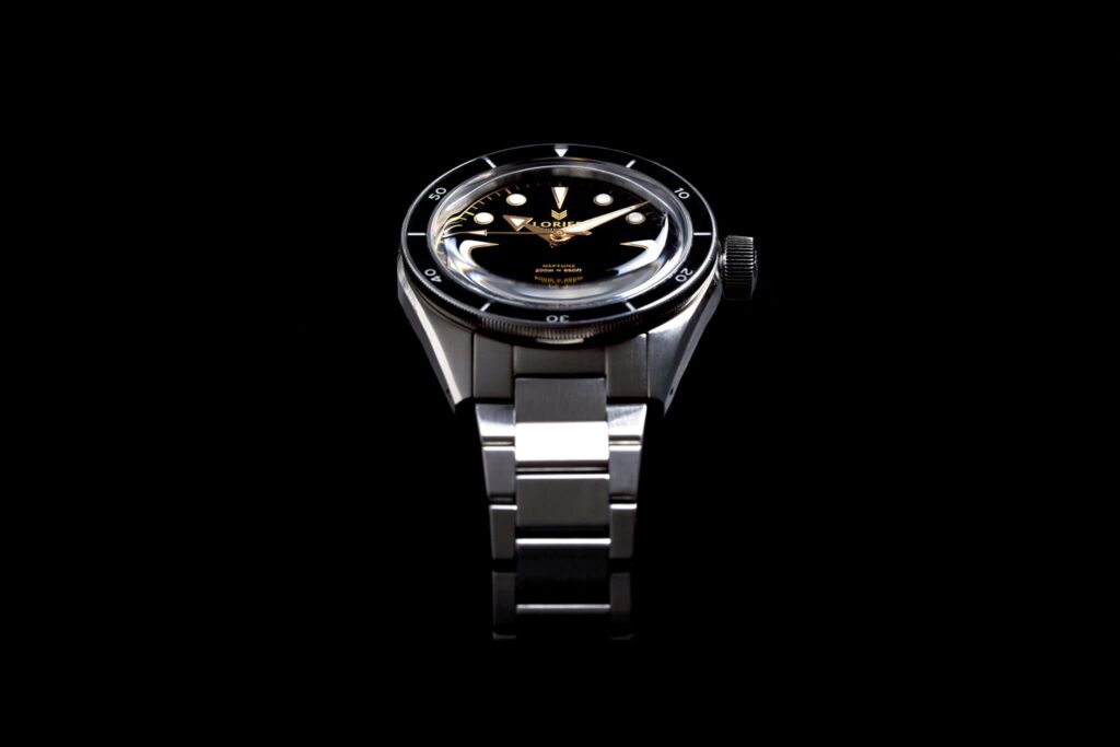 Worn & Wound Buys Lorier in a Landmark Microbrand Watch Deal Lorier watch on a desk beside watch tools and editorial notes