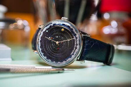 A luxury celestial wristwatch with moon phase and planetary display on a starry dial