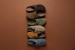 A curated August 2026 style edit featuring clogs, high-top sneakers, a carry-on suitcase, suede holdall and football apparel