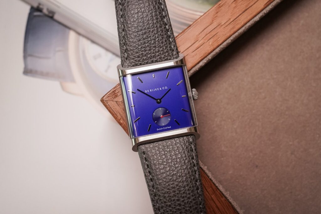 Five elegant dress watches arranged together on a refined neutral surface