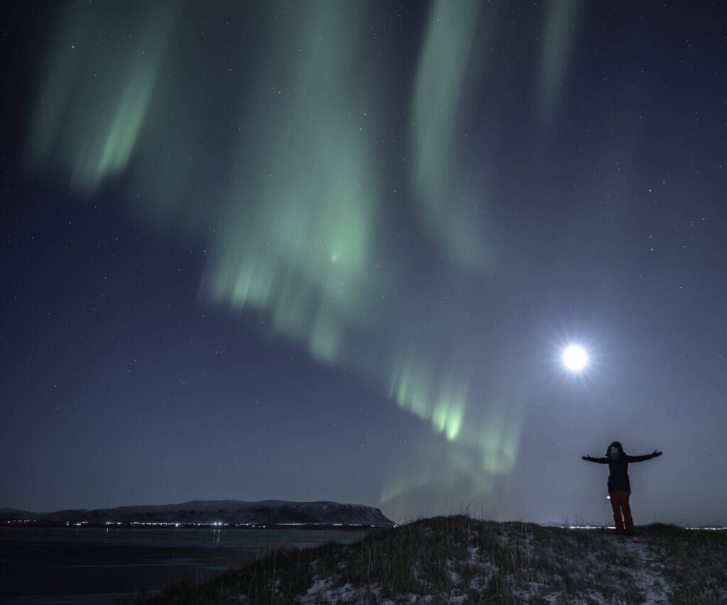 The Case for a Private Northern Lights Hunt in Iceland Travellers watching the northern lights beside a private vehicle in Iceland