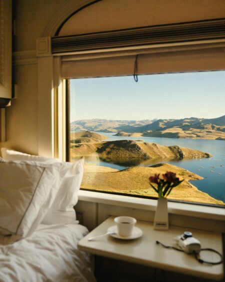 Séntire Brings Sensory-Led Luxury Travel Into Sharper Focus Luxury traveller overlooking a quiet lakeside destination at golden hour