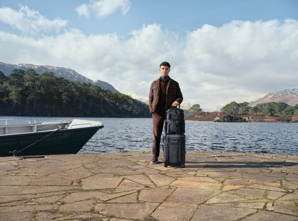 Lando Norris with TUMI luggage in a rugged Scottish highlands setting for Autumn Winter 2026