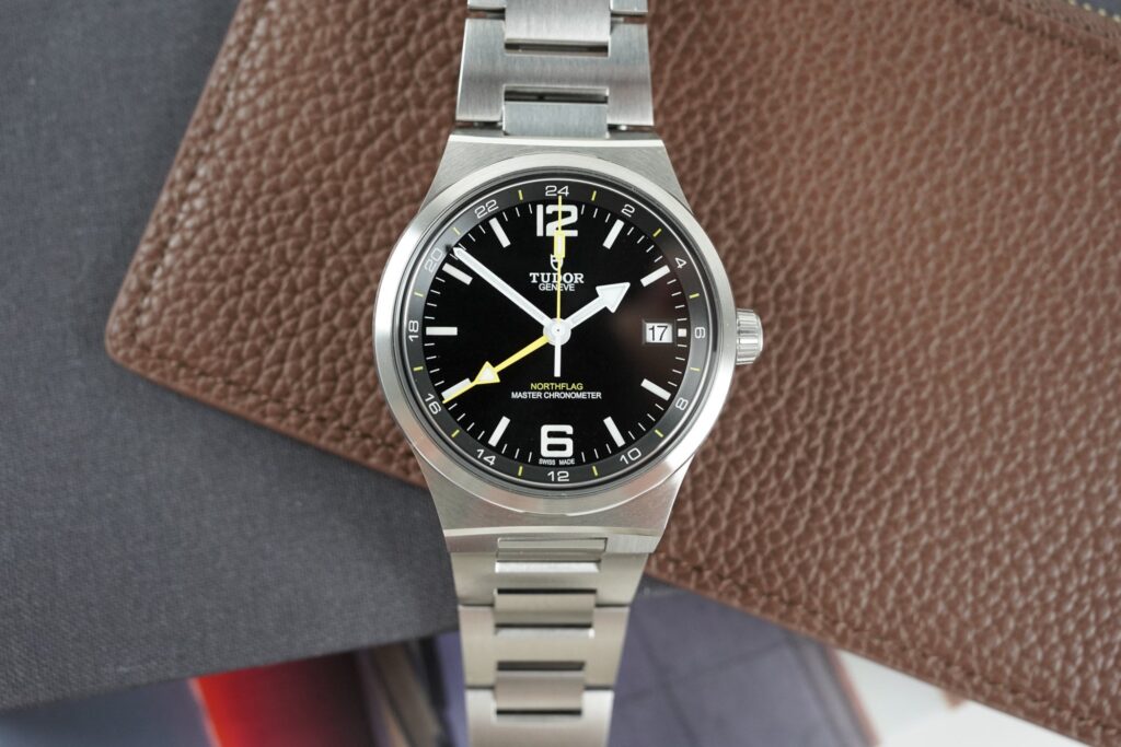 Luxury travel watches arranged with a passport and boarding pass