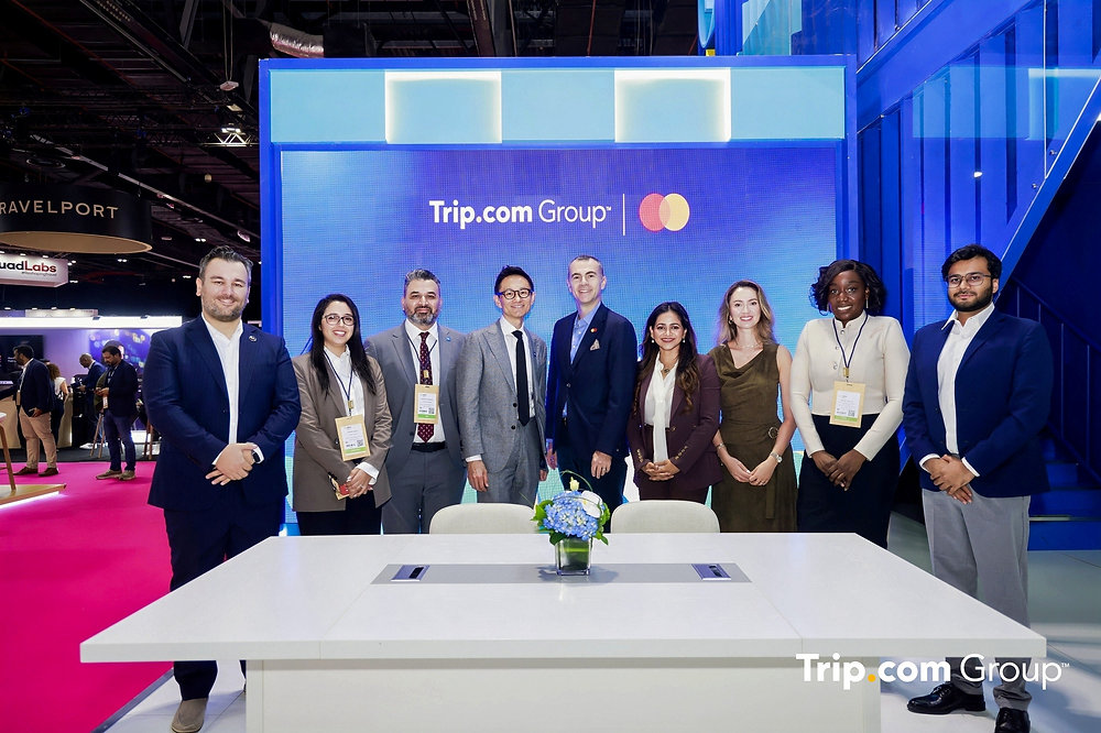 Mastercard and Trip.com Bring AI Travel Booking Closer to Checkout Traveler using an AI-powered travel booking assistant on a smartphone at an airport lounge