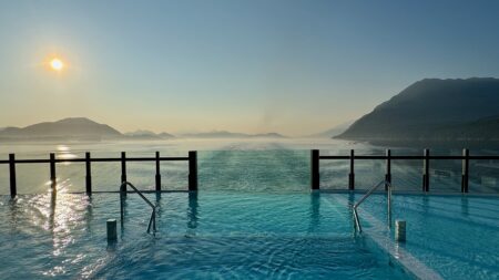 Luminara sailing through Alaska’s Inside Passage with forested mountains and calm water