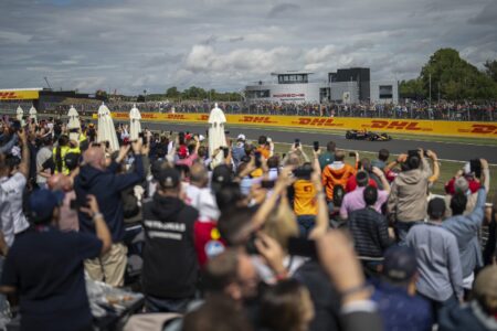 Formula 1 cars racing at Silverstone during the British Grand Prix with premium hospitality terraces nearby