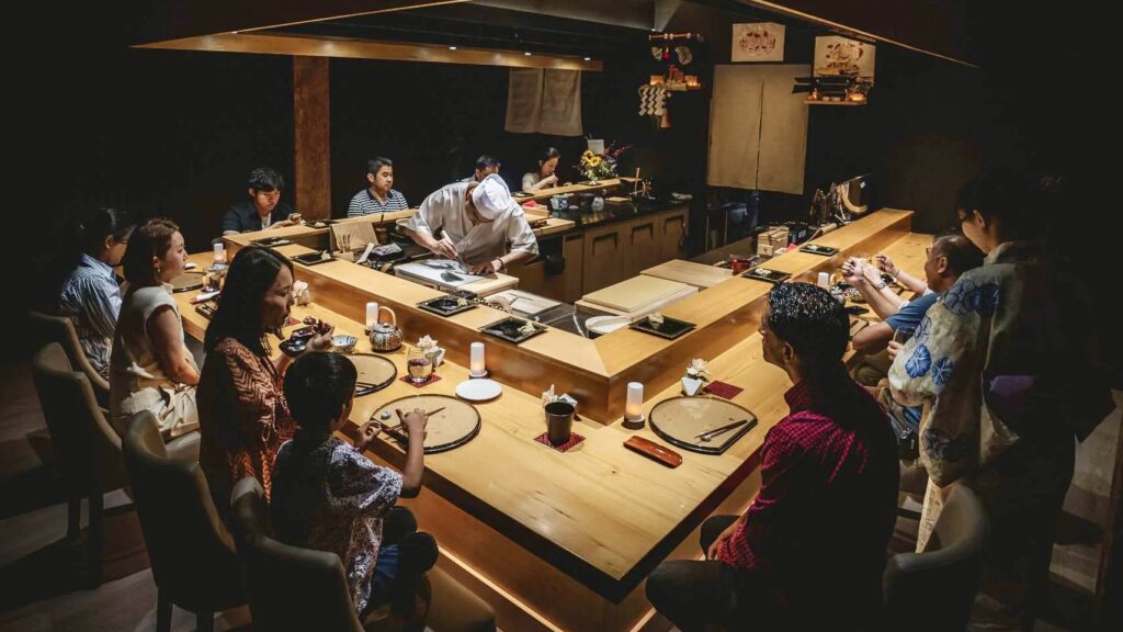Inside Okeya Kyujiro Vancouver’s Theatrical Michelin-Starred Omakase Chefs preparing sushi at an intimate omakase counter in a dark Michelin-starred Japanese restaurant in Vancouver