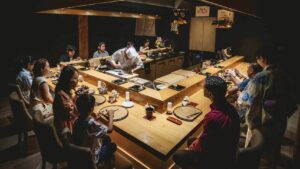 Chefs preparing sushi at an intimate omakase counter in a dark Michelin-starred Japanese restaurant in Vancouver