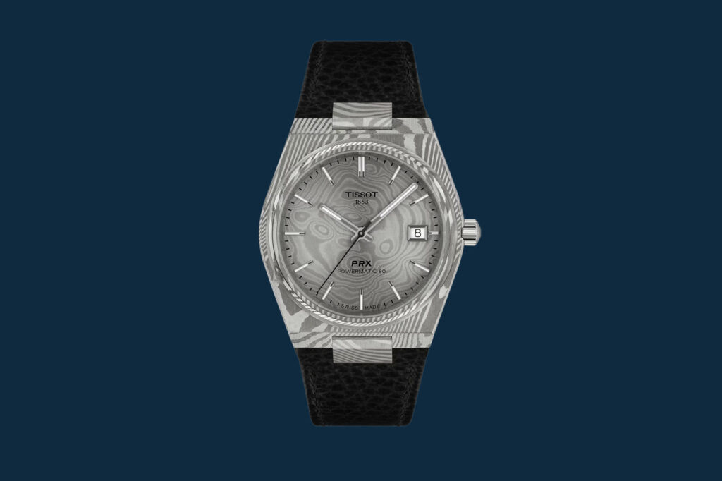 The Watch Auctions and Events to Know in September 2026 Collectors viewing luxury watches at a watch event with classic cars in the background