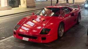 Red Ferrari F40 parked on a London street at night with Monaco licence plates