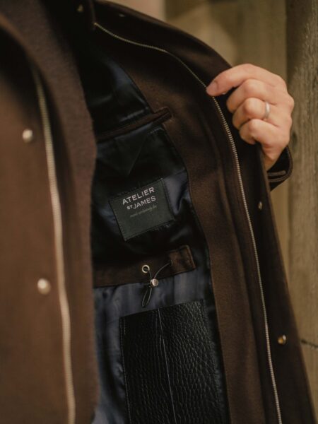 A bespoke tailor working on a refined jacket inside a London tailoring atelier