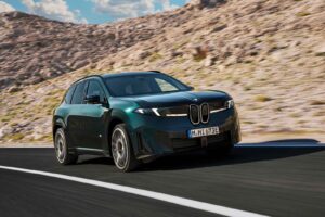 BMW iX3 M60 xDrive electric SUV driving on a modern road