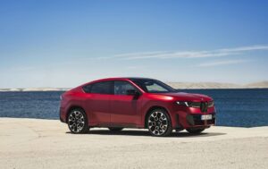 BMW iX4 50 xDrive electric SUV driving on a modern road
