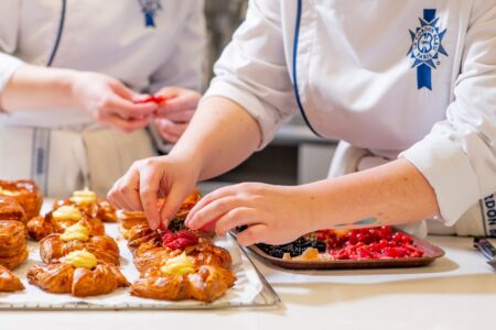 Students preparing dishes in a professional teaching kitchen at Le Cordon Bleu London