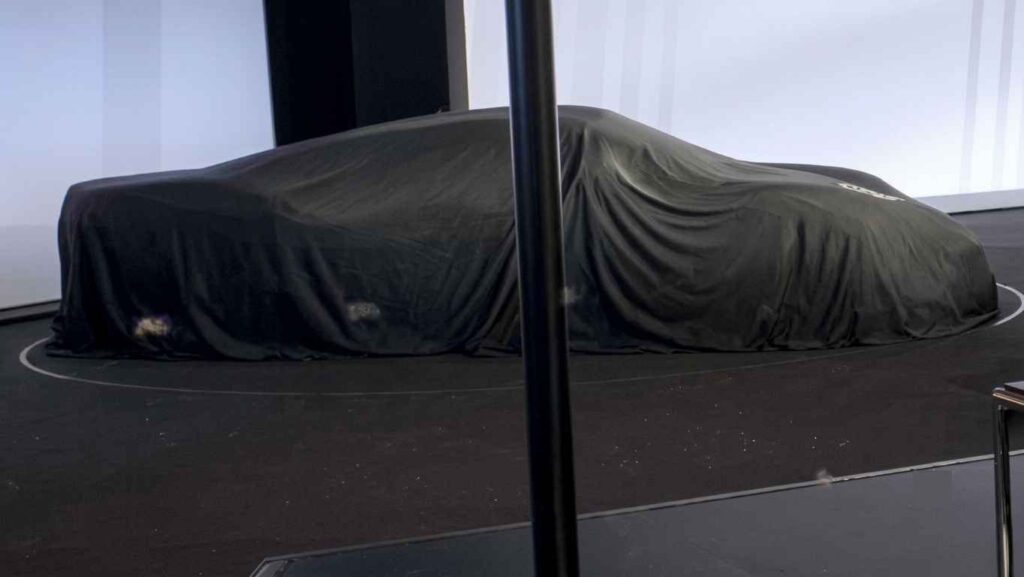 Porsche Mission S Breaks Cover in a Shadowy Investor Presentation Image Porsche Mission S concept hidden beneath a black cover showing a low aggressive silhouette