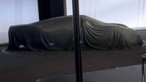 Porsche Mission S concept hidden beneath a black cover showing a low aggressive silhouette